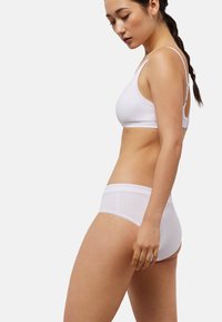 Sujetador de algodón blanco y braguitas a juego con textura suave, diseño sencillo, tirantes ajustables y delicado borde de encaje.