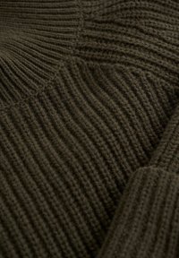 Tissu tricoté vert olive foncé avec une texture côtelée en motifs diagonaux et verticaux, montrant un gros plan détaillé du travail de points.