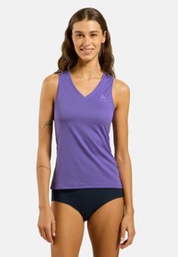 Purple athletic tank top with a V-neck design, made of breathable fabric, featuring a small logo on the left chest area. Paired with black bottoms.