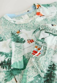 Hellgrünes Pyjama-Set aus weicher Baumwolle mit verspielten, winterlichen Drucken von Bäumen, Tieren und Sternen. Inklusive verstellbarem Taillenzug.