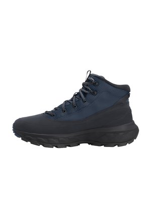 Scarpa da trekking blu navy e nera con suola spessa, colletto imbottito alla caviglia, tomaia in tessuto strutturato e lacci neri su sfondo bianco.