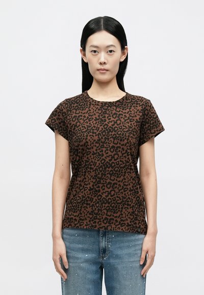 Καφέ T-shirt με λεοπάρ σχέδιο, κοντά μανίκια, στρογγυλή λαιμόκοψη και λείο ύφασμα, συνδυασμένο με μπλε τζιν παντελόνι με διακοσμητικά στοιχεία.