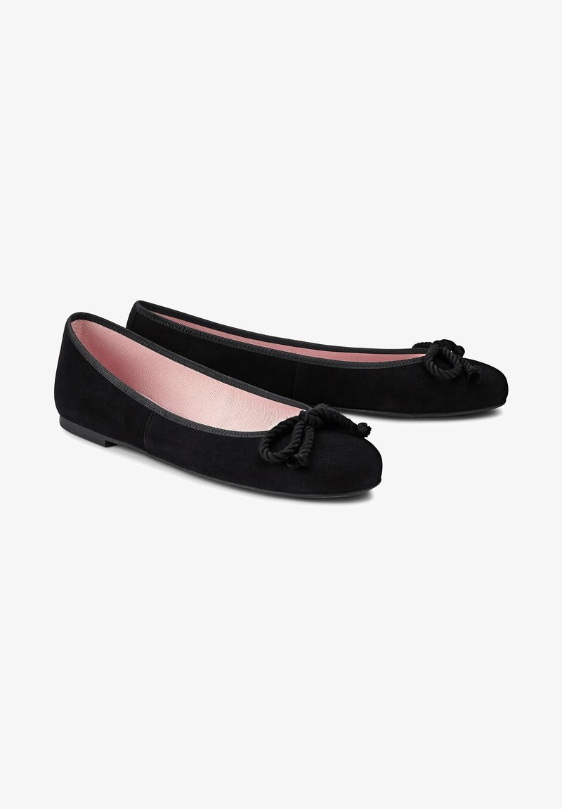 Ballerines en suede noir avec un bout rond, présentant un détail noué à l'avant. Intérieur doublé en tissu rose doux. Talon plat.