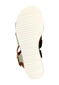 Flache Sandalensohle aus weißem Gummi mit horizontalen Rillen, hellgrünen Riemen und einem braunen Akzentriemen. Minimalistisches Design.