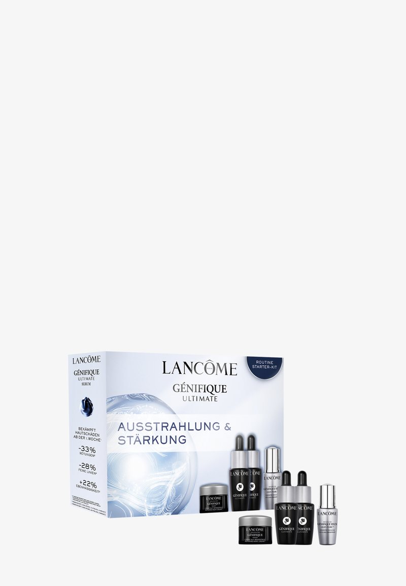 Coffret de soins ultimes Lancôme Génifique avec des contenants argentés et noirs, arborant un logo bleu en évidence et des détails sur les produits.