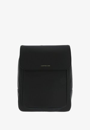 Mochila negra de material sintético suave. Presenta un cierre con solapa, un diseño minimalista y un sutil logo dorado en la parte frontal.
