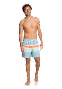 Pánske plavky v svetlomodrej farbe s horizontálnymi pruhmi v rôznych farbách. Obsahujú elastický pás a šnúrku na stiahnutie. Hladký povrch.