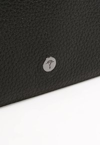 Portafoglio in pelle nera con texture, caratterizzato da un accento circolare in metallo argentato con un design embossato di un albero.