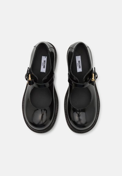 Mustad nahast Mary Jane kingad ümmarguse varbaga, ankle strap ja kuldsed aksessuaarid. Sile tekstuur, nähtavad ümarad lõiked.