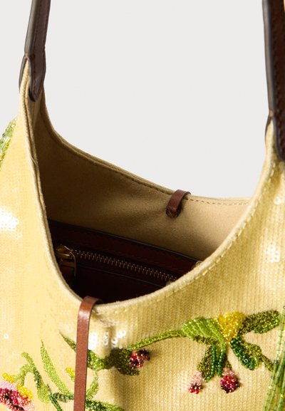 Żółta torebka z cekinów z zielonym i różowym koralikowym haftem w kwiaty oraz brązowymi skórzanymi uchwytami, ukazująca beżowe wnętrze i kieszonkę na zamek.