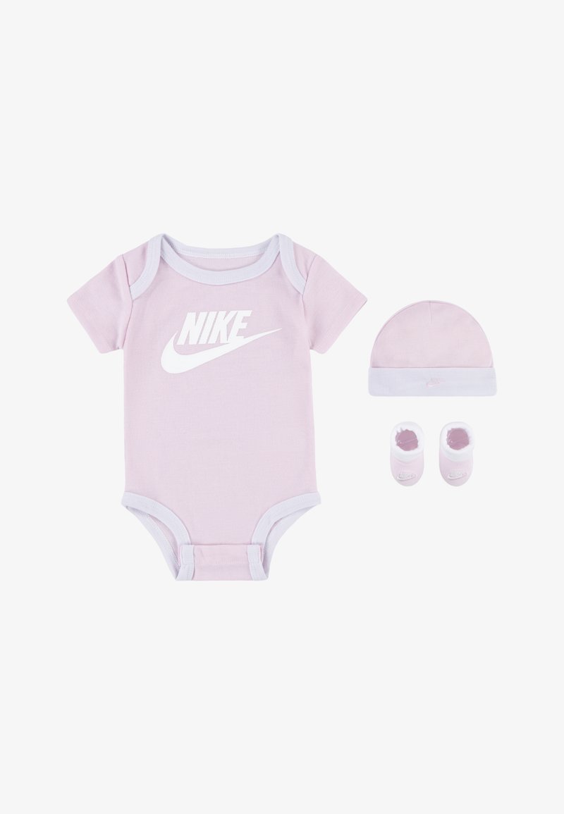 Różowy bawełniany kombinezon z białym logo Nike, uzupełniony dopasowanym różowym czapkiem z białym wykończeniem oraz różowymi bucikami z białymi akcentami.