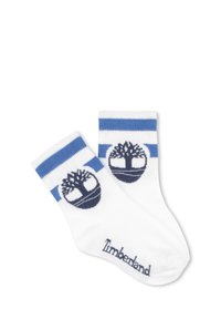 Calzini bianchi in cotone con righe blu nella parte superiore, caratterizzati da un logo albero navy e il testo "Timberland" in navy vicino alla punta.