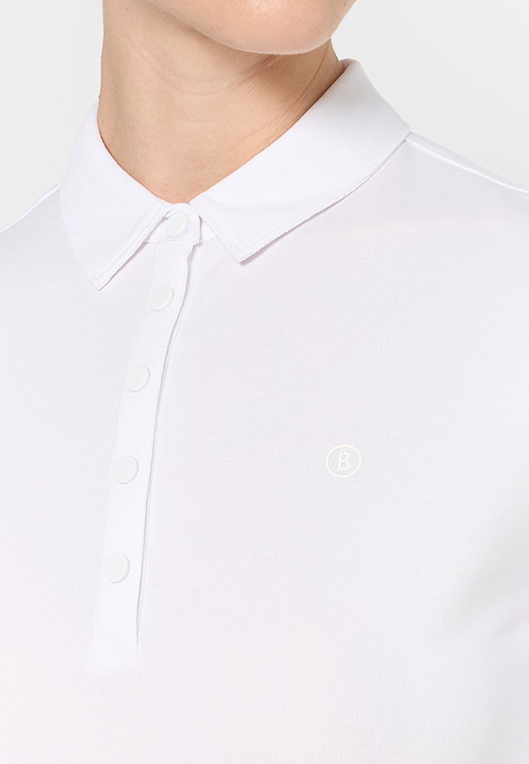 Weißes Poloshirt mit klassischem Kragen, fünf Knöpfen und einem kleinen geprägten Logo auf der linken Seite. Strukturierter Stoff mit glatter Oberfläche.