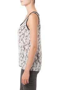 Bezrukávový top v černo-bílém geometrickém vzoru s uvolněným střihem, kulatým výstřihem a kontrastním lemováním na průramech.