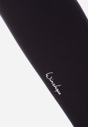 Zwarte stretchleggings met een soepele textuur en een aansluitend ontwerp, voorzien van een wit scriptlogo op het onderbeen.