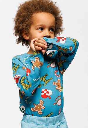 Long-sleeve shirt in light blue fabric featuring colorful candy and gingerbread patterns. Soft texture with round neck and fitted sleeves.