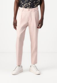 Ljust rosa skräddarsydda byxor med texturerad tyg, smal passform, framfickor och bälteshällor, kombinerat med vita sneakers.