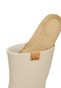 Bottine blanche en caoutchouc avec une semelle intérieure beige partiellement visible à l'intérieur. Présente une semelle texturée et une petite étiquette en cuir tan avec le logo "BRK".