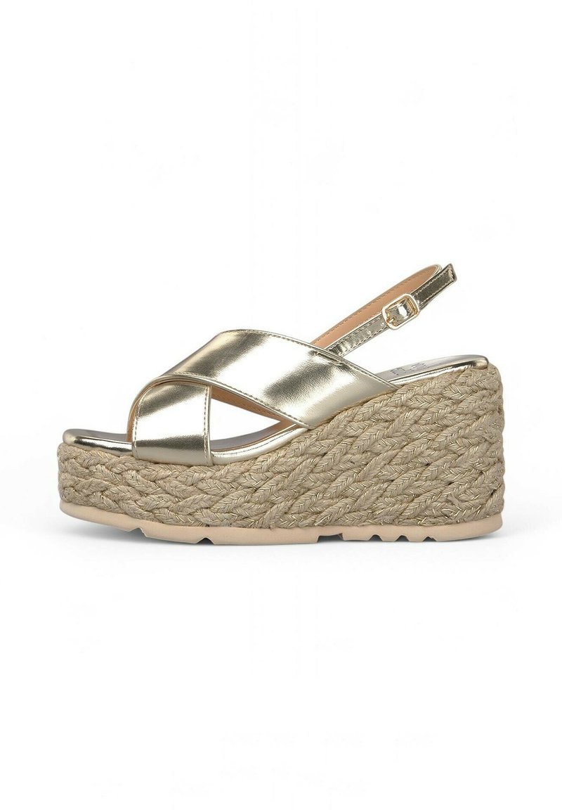 Goldene metallische Wedge-Sandale mit überkreuzten Riemen und verstellbarem Knöchelriemen. Der Wedge ist aus gewebten Naturfasern gefertigt. Flache Gummisohle.