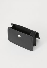 Cartera de cuero negro con textura suave, forma rectangular, cierre a presión y compartimentos abiertos que muestran detalles interiores mínimos.