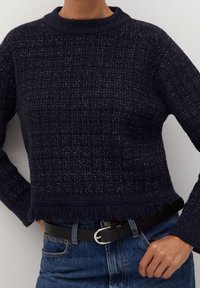 Maglione corto blu navy in tessuto testurizzato con un leggero luccichio. Presenta un collo a girocollo a coste e dettagli frangianti sull'orlo. Abbinato a una cintura nera.