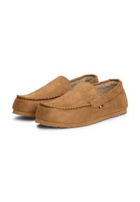 Scarpe slip-on in suede marrone con un design a mocassino cucito, fodera morbida e suola piatta in gomma. Presentano un piccolo accento con il logo sul lato.