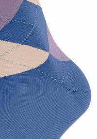Wielokolorowa skarpetka z geometrycznymi wzorami w odcieniach niebieskiego, lawendy i beżu. Wykonana z miękkiego, elastycznego materiału z widocznymi szwami.