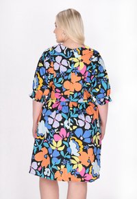Rochie florală cu un model colorat de flori pe un fond negru, cu mâneci scurte cu margini volănașe și detaliu la talie elastic.