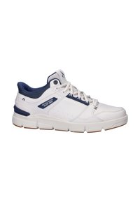 Witte sportieve schoen met blauwe accenten, synthetisch bovenwerk, gevoerde kraag en vetersluiting aan de voorkant. Bevat een dikke rubberen zool met tractiepatroon.