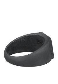 Sort metalkrans med en glat, mat finish. Har en flad, vinklet top og en let tilspidsning mod bagsiden. Graveret med små mærker.