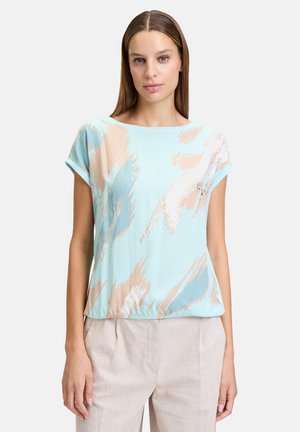 Light blue short-sleeve top with abstract beige and teal patterns, featuring a round neckline and relaxed fit, made from lightweight fabric.