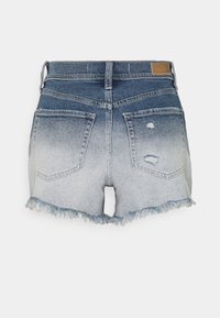 Džínové šortky s bledým modrým gradientem, roztrhaným lemem a dvěma zadními kapsami. Materiál vykazuje opotřebení s vlastnostmi opotřebení.