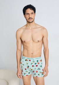 Hellblaue Boxerbriefs mit floralen Mustern in Rot, Gelb und Grün. Elastischer Bund mit "BJÖRN BORG"-Branding. Weicher, glatter Stoff.
