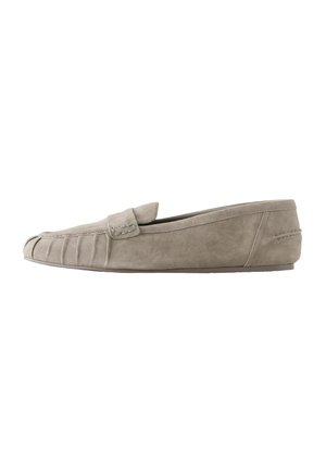 Beige suede flat loafer with stitched detailing and a small strap across the upper side, featuring a slim, smooth sole.