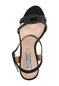 Sandalo con tacco in suede nero, dotato di un sottile cinturino alla caviglia, dettaglio decorativo in catena sulla punta e soletta imbottita beige.