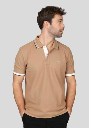 Polo shirt beige avec un col blanc et des accents à rayures noires, manches courtes avec des poignets assortis, et un petit logo sur la poitrine.