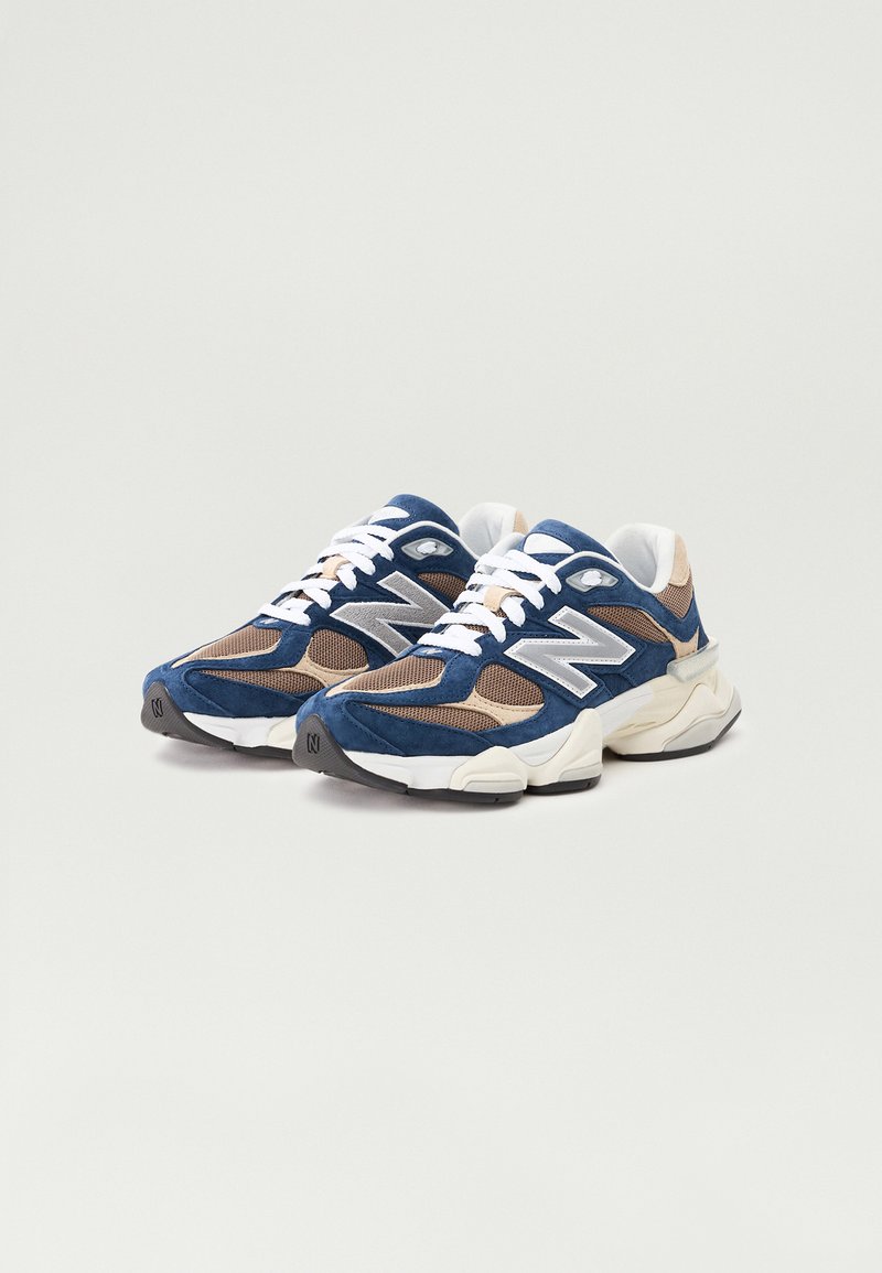 Niebieskie i beżowe sneakersy z siateczkowych i zamszowych materiałów, białe sznurowadła, duże logo "N" oraz gruba gumowa podeszwa.