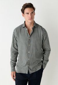 Kariertes Hemd in Blau, Grün und Creme. Lange Ärmel, Button-Down-Kragen und Frontknöpfe. Weicher Stoff mit regulärer Passform.