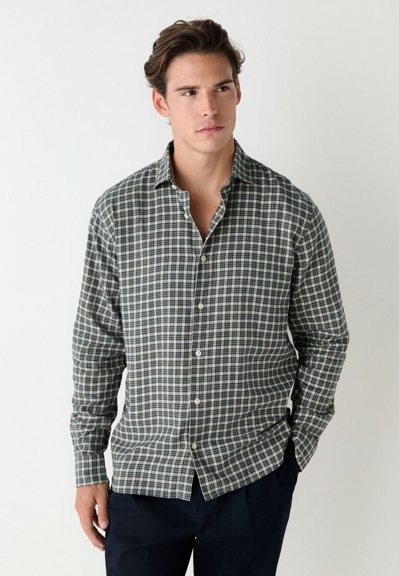 Kariertes Hemd in Blau, Grün und Creme. Lange Ärmel, Button-Down-Kragen und Frontknöpfe. Weicher Stoff mit regulärer Passform.