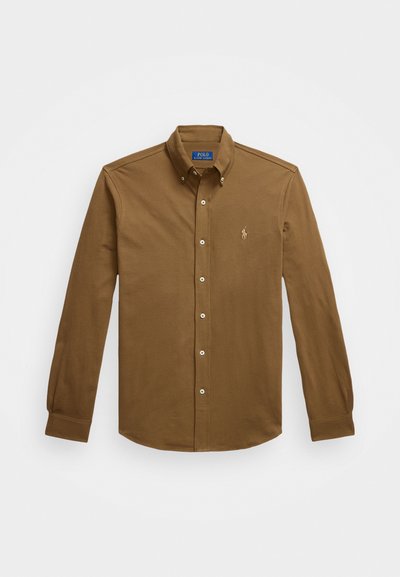 Brown long-sleeve button-down shirt made of cotton. Features a collar, button-front closure, and small embroidered logo on the chest.