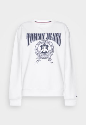 Fehér pulóver, amelyen a "TOMMY JEANS" logó sötétkékkel, kör alakú emblémával és vízszintes csíkokkal a nyakrészen. Puha anyagból készült, sportos dizájnnal.