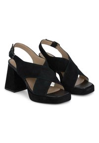 Sandales à talons hauts en suédine noire avec un design à bride arrière, des brides croisées et un bout carré, dotées d'un large talon bloc et d'une plateforme lisse noire.