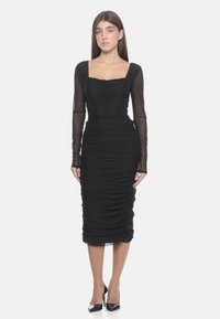 Zwart gerimpeld jurkje met lange doorschijnende mouwen, vierkante halslijn en aansluitende silhouet, met een textuurstof en tot halverwege de kuit reikend.
