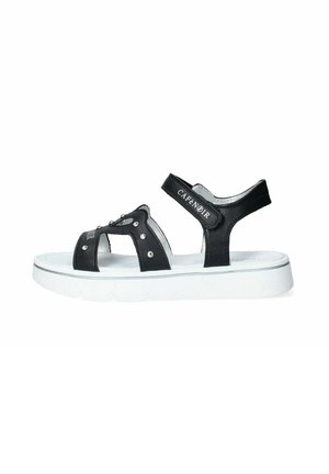 Sandal nero con suola bianca, dotato di cinturini regolabili, borchie in metallo e dettagli con logo. Il materiale sembra liscio con una leggera lucentezza.