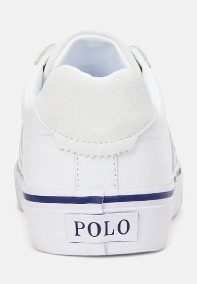 Fehér sneaker, nubuk részletekkel, lekerekített háttal, sötétkék csíkkal a talpon, és egy fehér címkével, rajta "POLO" felirattal a saroknál.