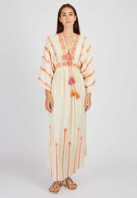 Leichtes Maxikleid aus Creme mit floralen Stickereien in Orange und Pink. Es hat einen tiefen Ausschnitt, lange Ärmel und Quastenbundchen an der Taille.