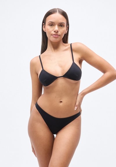 Σετ μαγιό μπικίνι σε μαύρο χρώμα από λεία ύφανση, με τριγωνικό τοπ με λεπτές τιράντες και εσώρουχα χαμηλής μέσης, που παρουσιάζει έναν μινιμαλιστικό σχεδιασμό.