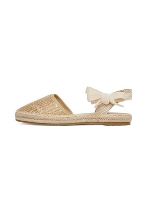 Beige geweven platte sandaal met gesloten teen, gevlochten jute zool en enkelbandje dat in een strik is gestrikt, geschikt voor casual zomerkleding.