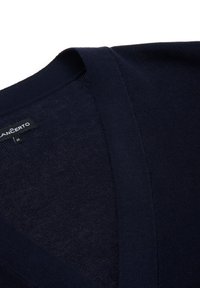 Granatowy sweter z dekoltem w serek wykonany z miękkiej dzianiny. Charakteryzuje się gładką fakturą oraz metką z nazwą marki i rozmiarem.