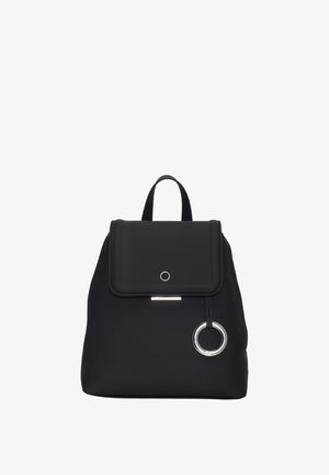 Černý batoh vyrobený z hladkého materiálu s klopou, kulatým kovovým akcentem a dvěma ramenními popruhy. Kompaktní a minimalistický design.